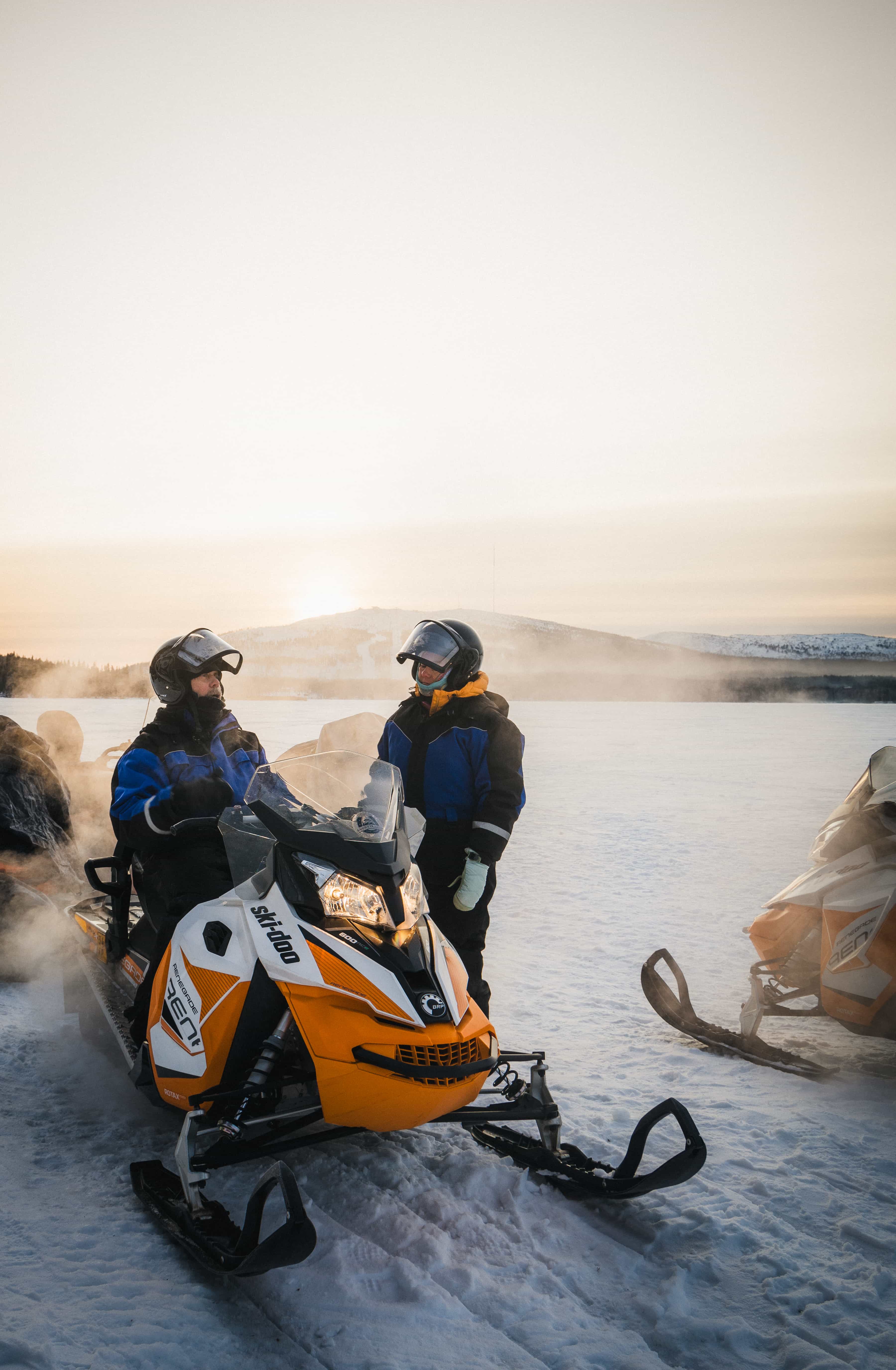 Two people holding snow surfing boards in snowy landscape