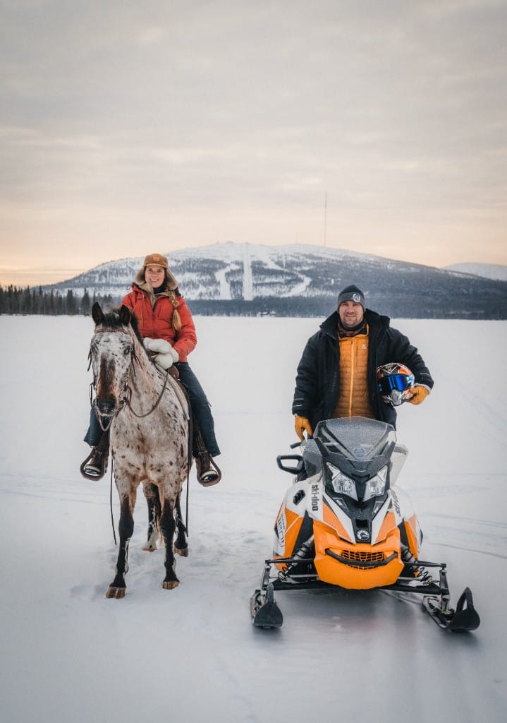 Ratsastaja ja moottorikelkkaopas jäätyneellä järvellä Lapissa